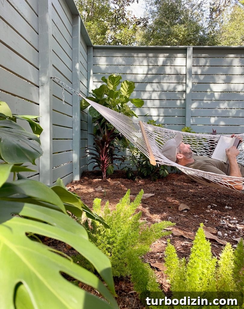 John Laying In Side Yard Hammock Amongst Tropical Plantings