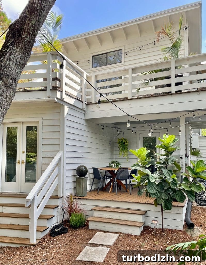 Full View of House With Kitchen Porch On First Floor With Plants And String Lights