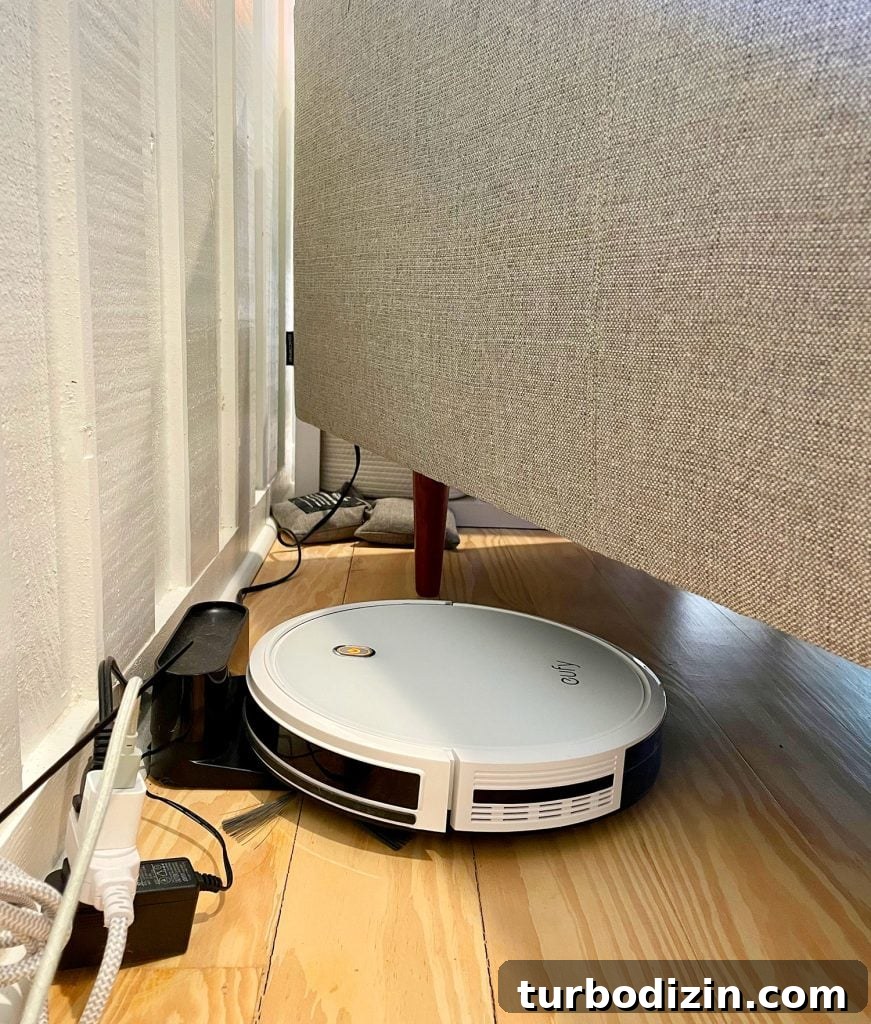 Are Robot Vacuums Worth the Investment? 14 Eufy RoboVac 11S Charging At Base Station Plugged In Under Couch