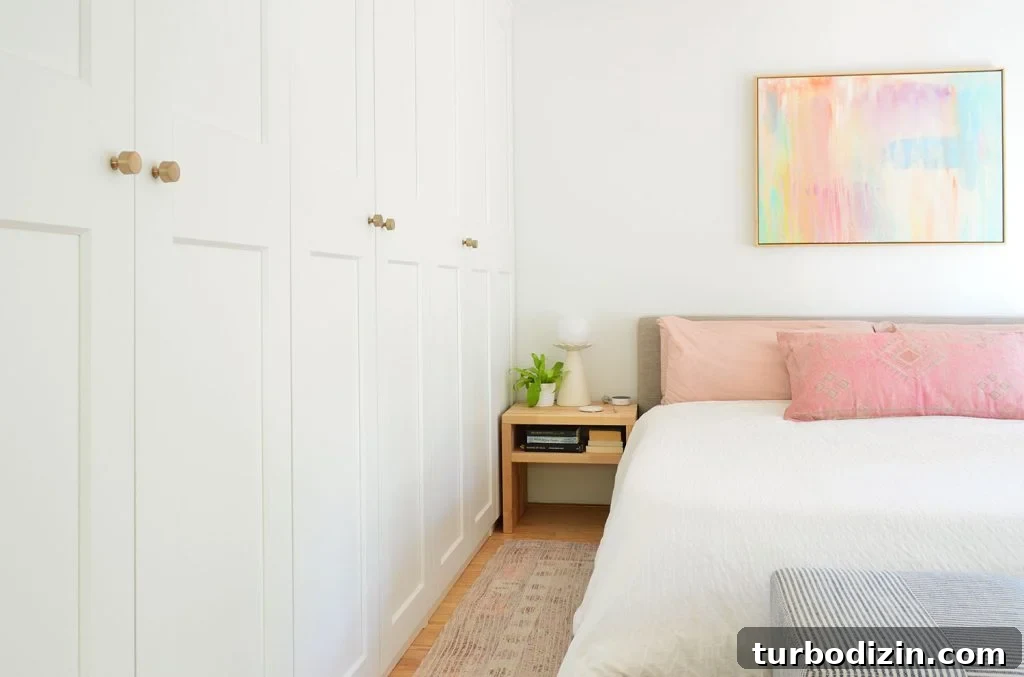 Make an Ikea PAX Wardrobe Look Like a Built-In Closet 2 Wall Of Ikea Pax Wardrobes Next to King Size Bed With Colorful Painting