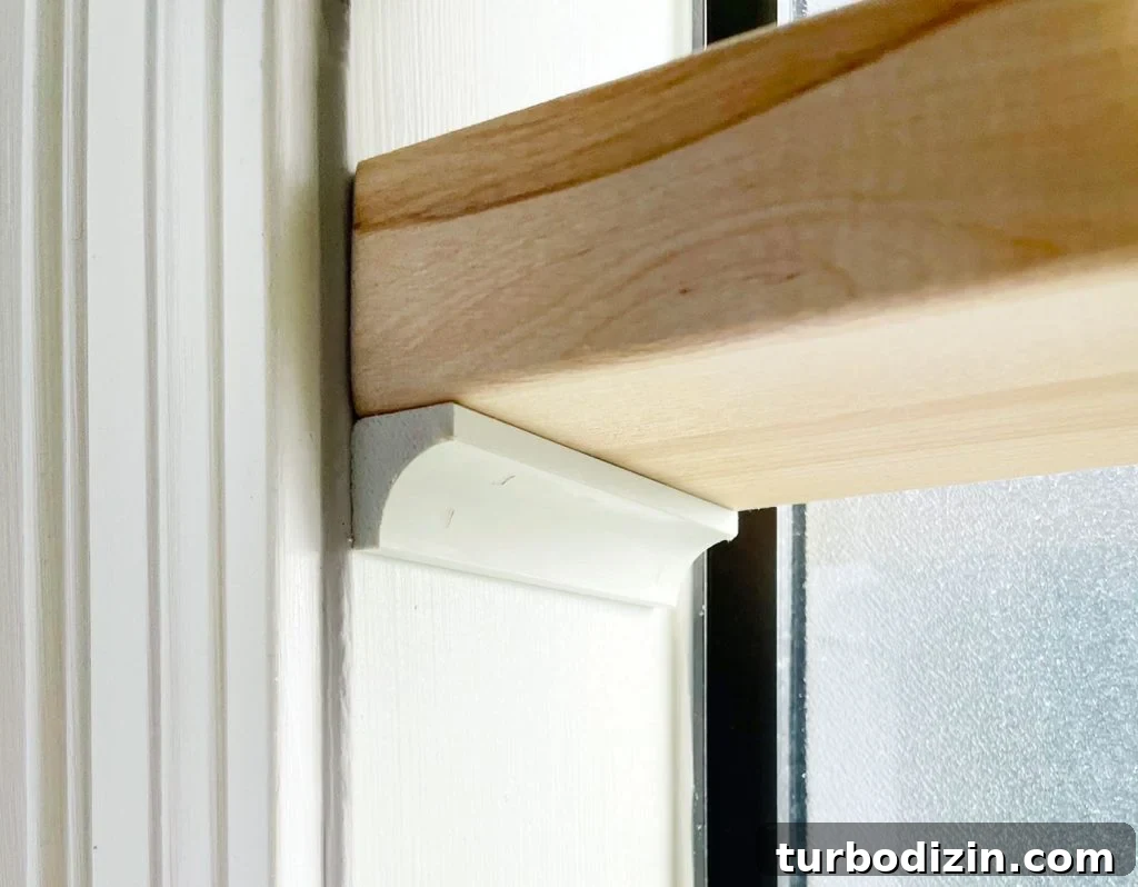 Close Up Of Butcher Block Shelf Propped Up On Cove Molding In Bathroom Window