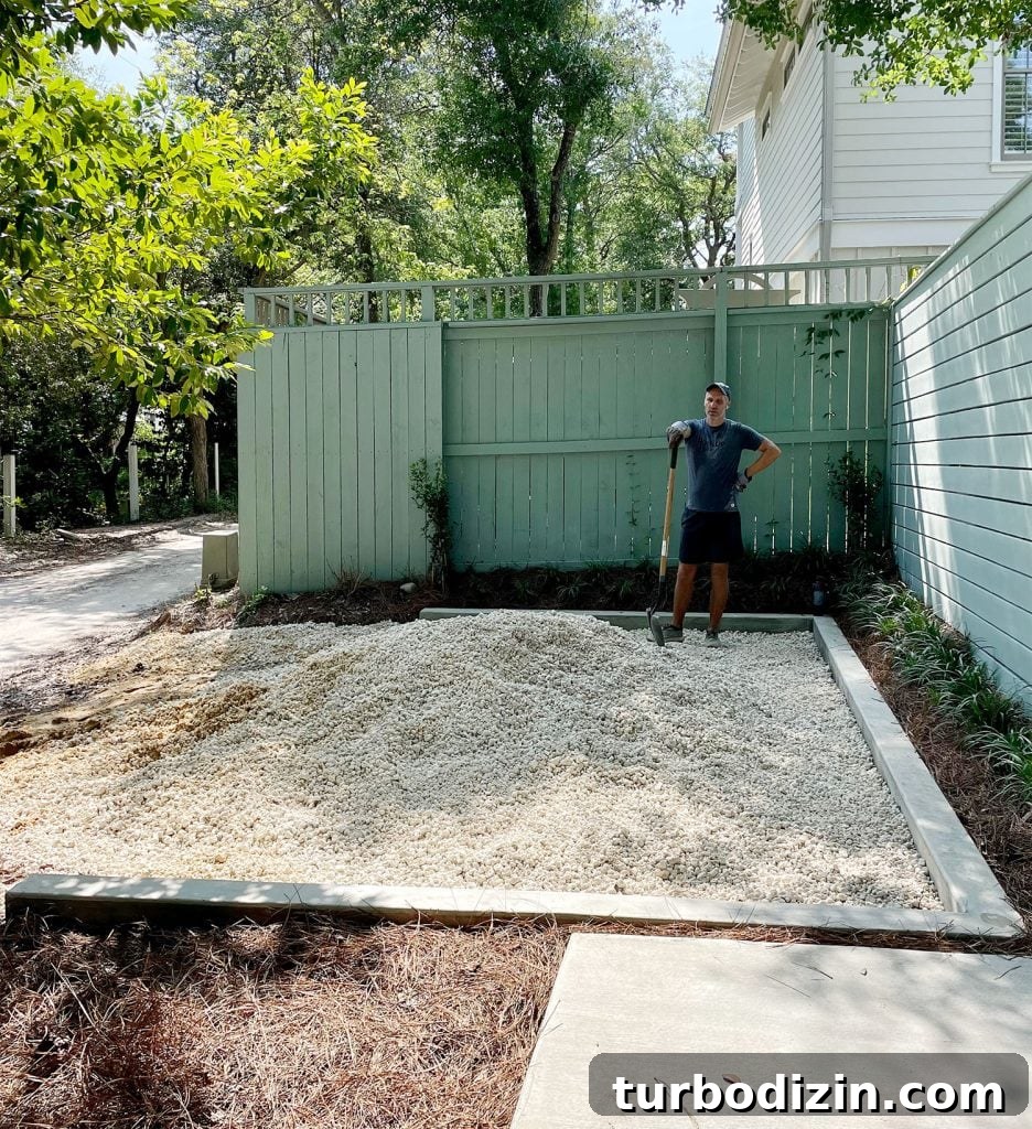 John with shovel spreading pile of bahama rock in driveway parking spot
