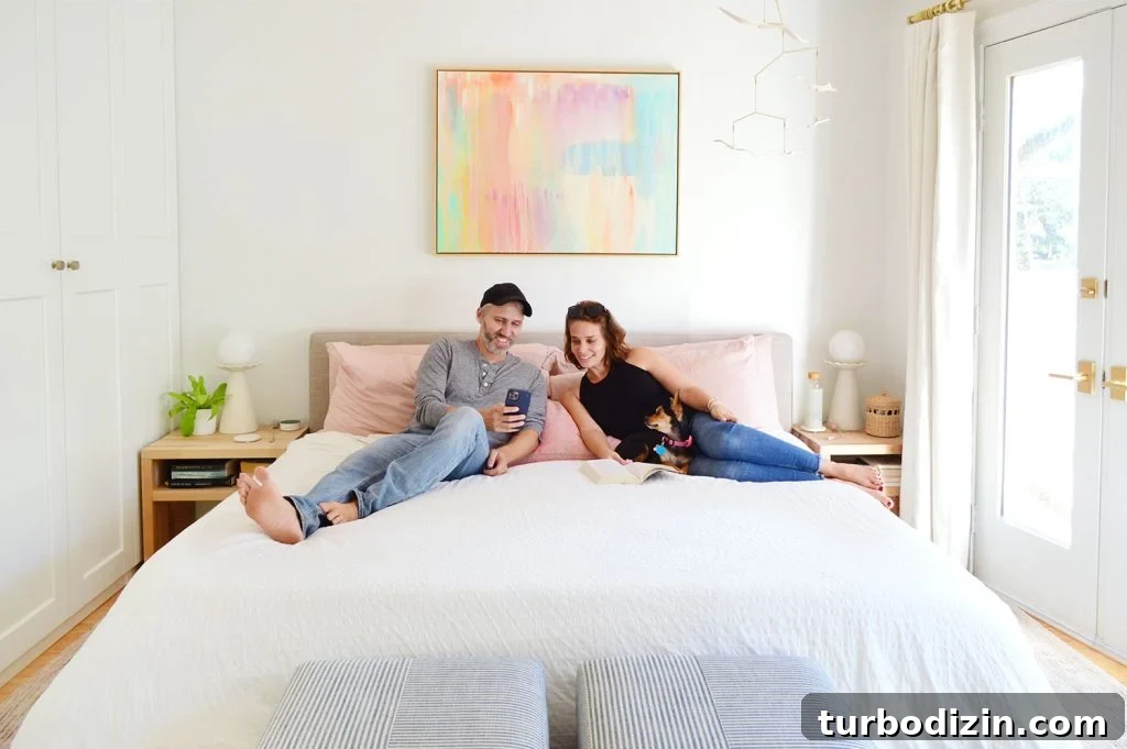 John And Sherry Looking At Phone With Dog On King Size Bed
