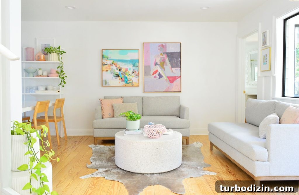 White Kitchen Sitting Area With Two Loveseats And Colorful Artwork