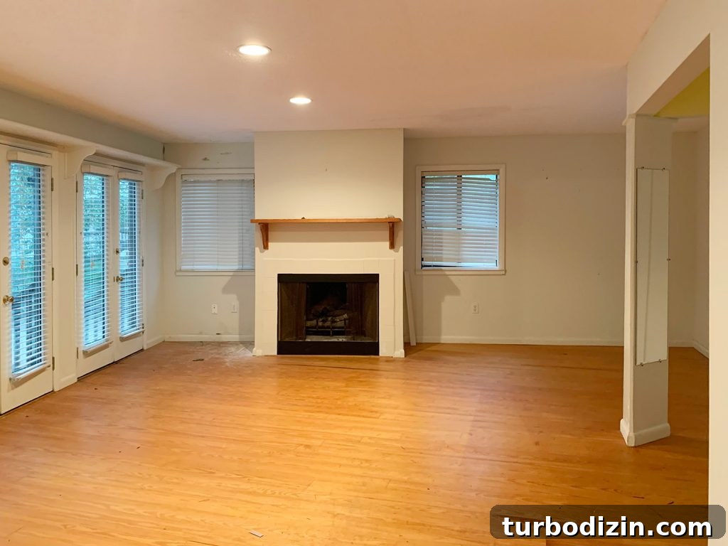 Before photo of bedroom with fireplace and blinds on windows