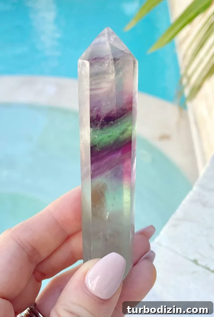 Rainbow Fluorite Meaning and Uses: Healing Properties & Care 2 Rainbow Fluorite Crystal Point In Hand By Pool