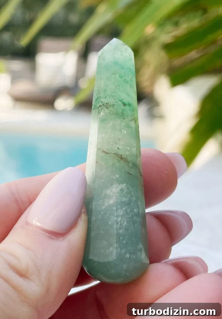 Green Aventurine Meaning & Properties: Uses, Benefits, and Care 3 Hand holding green aventurine crystal point