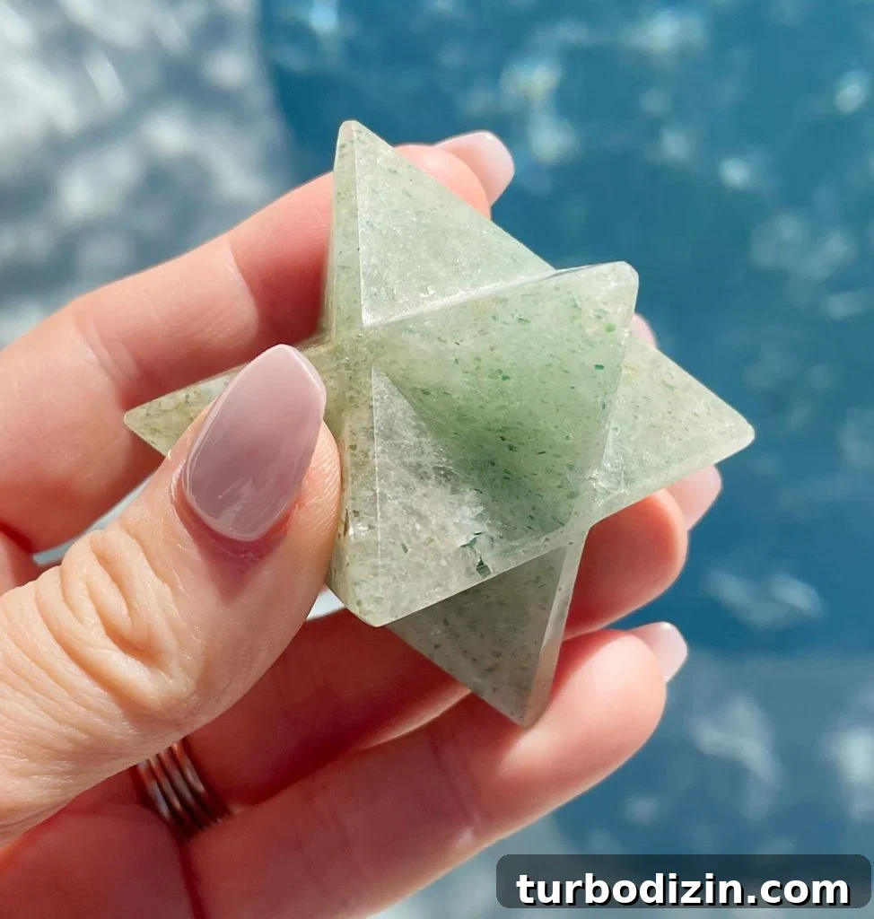 Green Aventurine Meaning & Properties: Uses, Benefits, and Care 7 Hand holding green aventurine merkaba asteroid over water