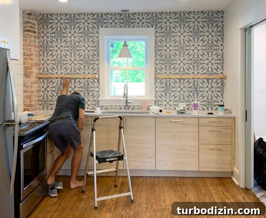 How to Install Floating Kitchen Shelves: Step-by-Step Guide 7 Man Crouching While Holding Kitchen Floating Shelf Bracket Against Tile For Placement