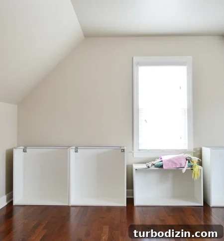 Built-In Cabinet Guide: Design, Installation, and Tips 5 Room with sloped ceiling and Ikea cabinet boxes being built, with a girl's doll using one as a window seat