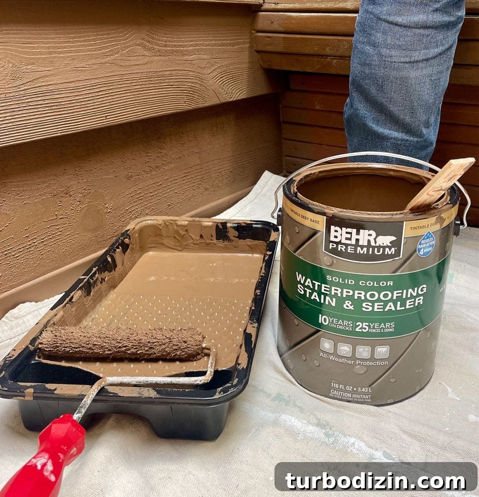 Can Of Behr Premium Solid Color Stain In Tugboat Next To Roller Tray