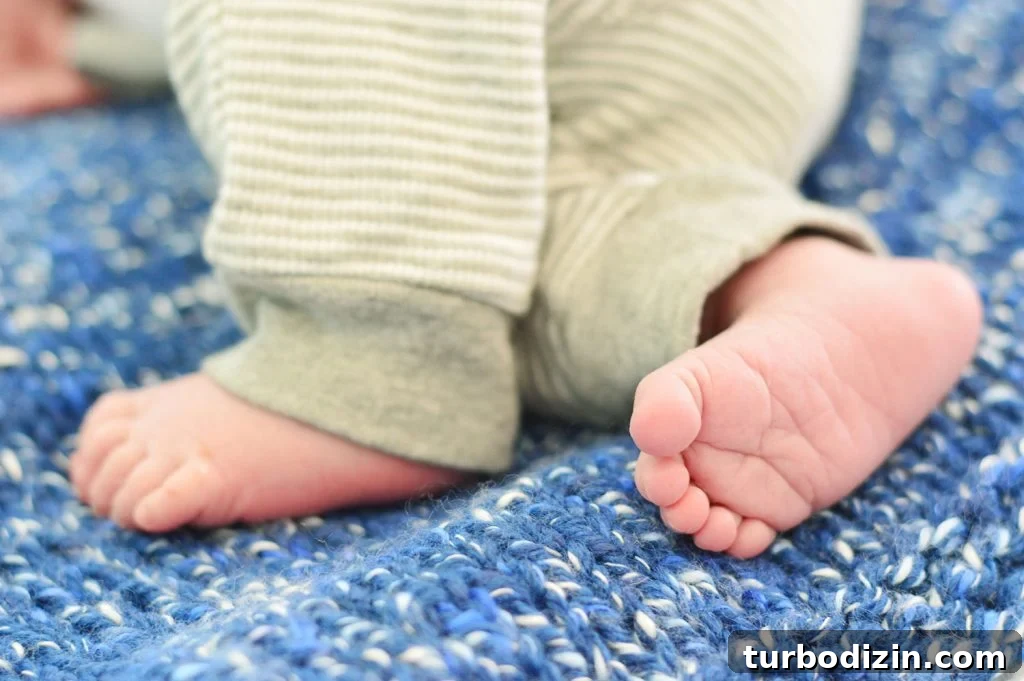 Small Newborn Baby Boy Feet On Blue Crochet Blanket