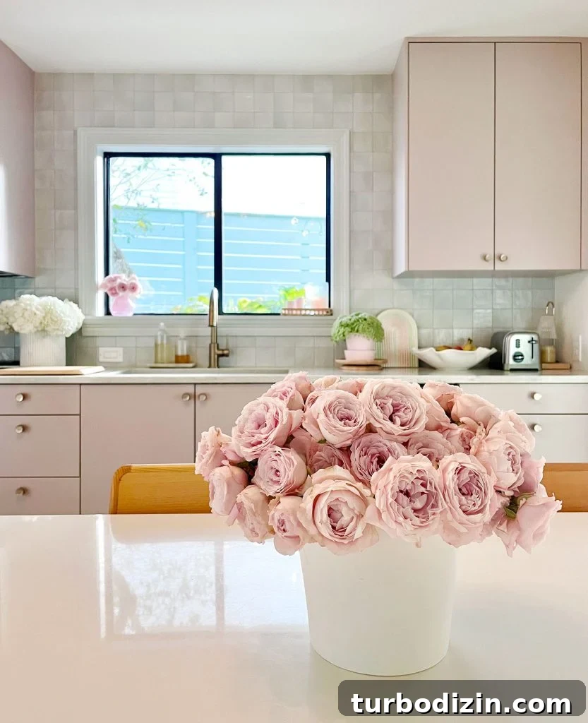 Pink Roses On Breakfast Table In Kitchen With Mauve Cabinets And Tile Backsplash