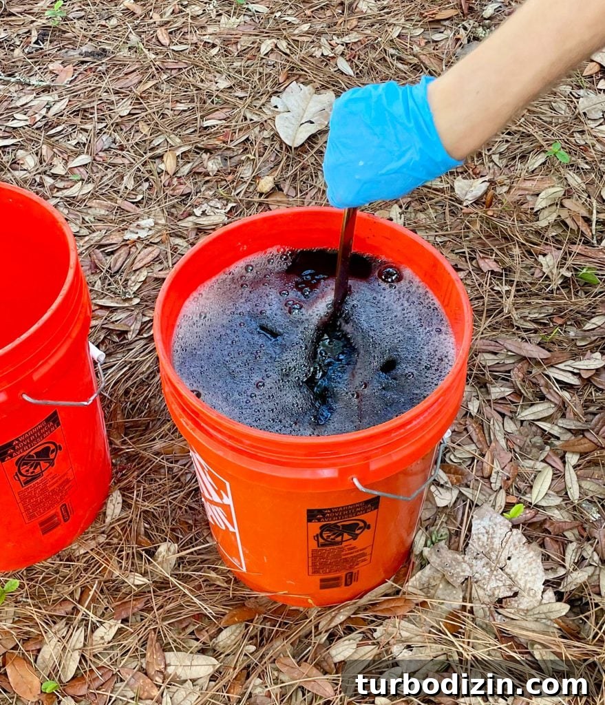 How to Dye Clothes at Home: Step-by-Step Guide for Vibrant Results 12 Hand Stirring Bucket Of Black Rit Fabric Dye With Clothes Inside