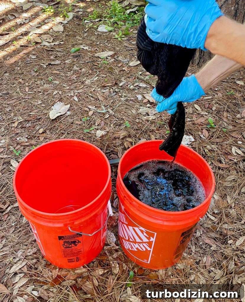 How to Dye Clothes at Home: Step-by-Step Guide for Vibrant Results 13 Squeezing Out Excess Fabric Dye From Black Sweater Over Bucket