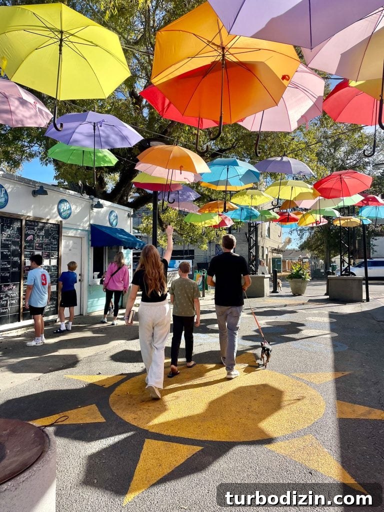 Weekend Escape to Ocean Springs: Coastal Things to Do and See 2 Kids Walking Under Bright Umbrellas In Cash Alley In Ocean Springs Mississippi