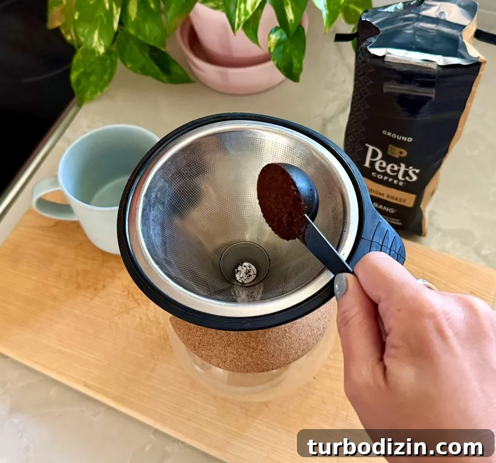 Adding One Scoop of Ground Coffee Into Pour Over Coffee Maker