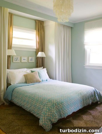 18 Expert Tips for Properly Hanging Curtains and Blinds 6 blue bedroom with curtain panels on all sides creating built in nook with wall sconces with blue bedspread and jute rug and capiz chandelier
