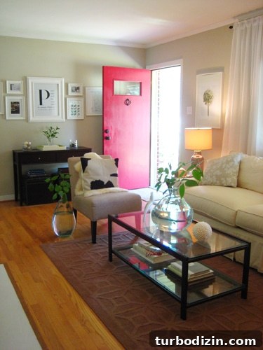 Living room view showing red front door and greenery