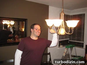 City Slickers: Urban Living Tips and City Survival Guide 4 Man posing with newly installed dining chandelier