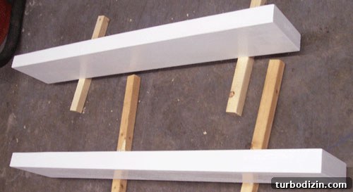 DIY Floating Shelves: Step-by-Step Build Guide with Ana White 5 DIY floating shelves propped up and painted white before hanging