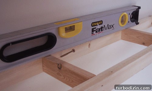 DIY Floating Shelves: Step-by-Step Build Guide with Ana White 6 attaching wood frame to wall using level for DIY floating shelves