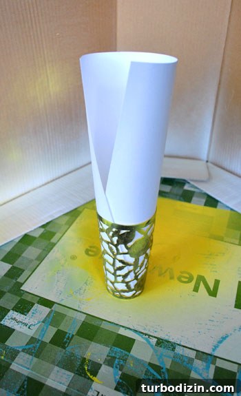 Paper rolled and inserted into cup before spray painting
