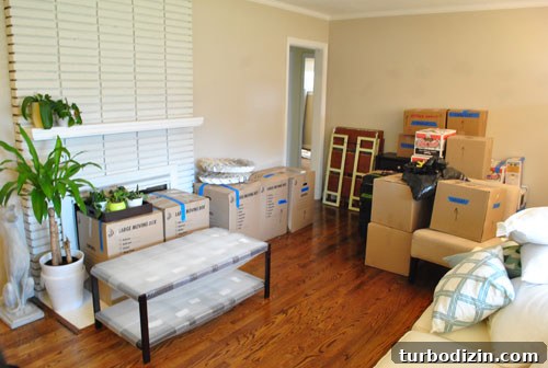 Living Room Filled With Moving Boxes And Packed Furniture