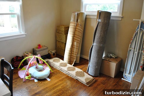 Guest Bedroom With Furniture Packed and Rugs Rolled Up Ready For Moving Truck