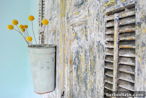 Close-up of chipped shutters with faux blooms