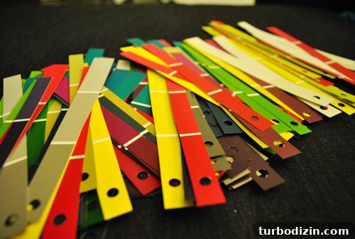 Kid-Friendly Christmas Tree Made from Paint Chips and Ribbons 9 Paint chip strips being punched