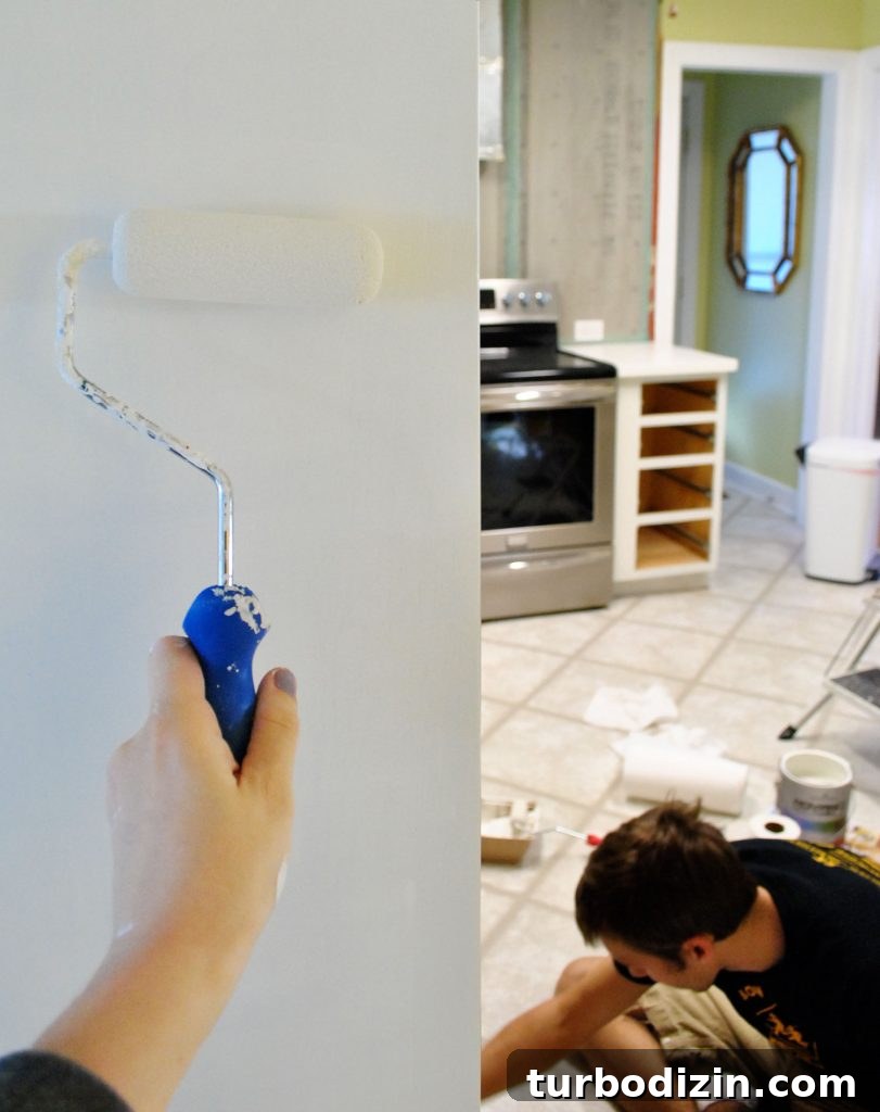 How to Paint Kitchen Cabinets Like a Pro: Step-by-Step Guide 11 Handing Painting Cabinet Box With Foam Roller