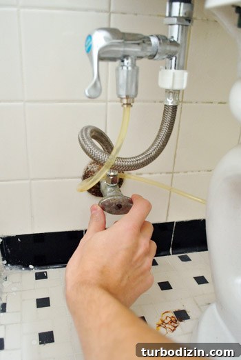 Fix a Wobbly Toilet: Quick Steps to Stabilize It Safely 3 Turning off water valve to toilet with cloth diaper sprayer attachment