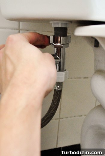 Fix a Wobbly Toilet: Quick Steps to Stabilize It Safely 25 Reattaching water supply line to underside of toilet tank