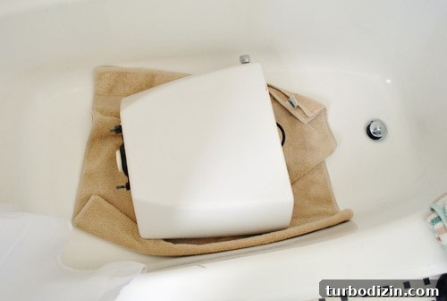 Fix a Wobbly Toilet: Quick Steps to Stabilize It Safely 8 Toilet tank resting safely on soft towel in tub during repair