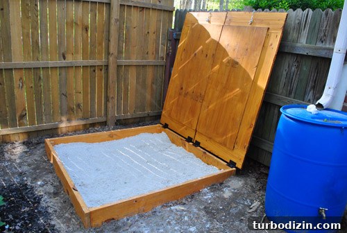 Rain barrel with closed lid near sandbox