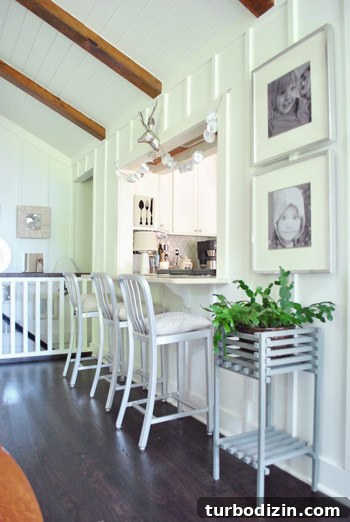 Breezy Bright House: Modern Coastal Home Tour 9 Kitchen pass-through with portraits