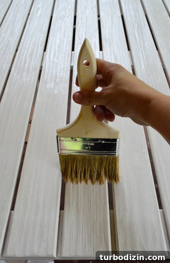 Protect Outdoor Furniture: Varnish vs. Teak Oil Guide 5 Brushing varnish into table slats
