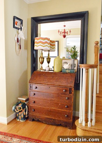 Entryway mirror with red chandelier reflection