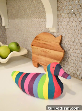 How to Paint a Vintage Thrift Store Wood Duck for Beginners 5 Finished striped wooden duck on kitchen shelf
