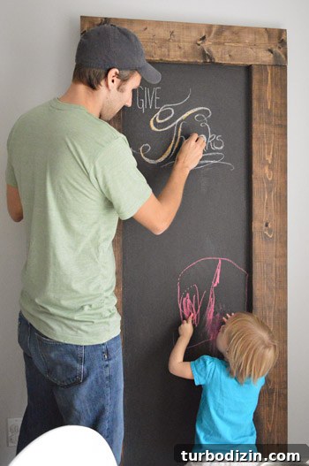 Create a Thanksgiving Gratitude Chalkboard for Your Home 2 John and daughter both writing on large leaning DIY chalkboard with wood frame