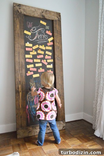 Create a Thanksgiving Gratitude Chalkboard for Your Home 12 Toddler girl drawing on DIY leaning chalkboard with Thanksgiving gratitude notes