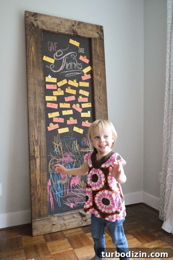 Create a Thanksgiving Gratitude Chalkboard for Your Home 13 Toddler girl standing in front of DIY leaning chalkboard with Thanksgiving gratitude notes