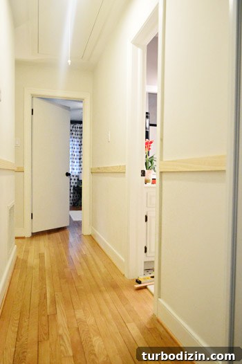 Board and Batten Wall Paneling for Under $60 9 progress on board and batten DIY project with top rails installed in hallway