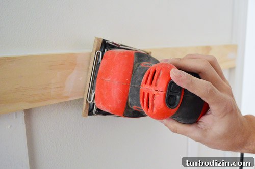 Board and Batten Wall Paneling for Under $60 15 using Black & Decker palm sander to smooth wood filler and spackle in DIY molding installation