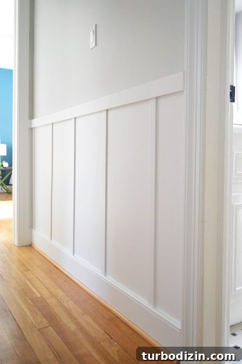 Board and Batten Wall Paneling for Under $60 20 close up of board and batten trim detail in gray hallway with wood floors