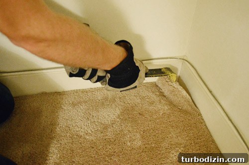 removing carpet with crowbar in corner
