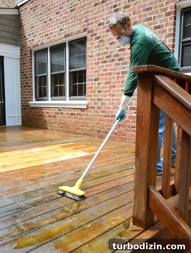 John Scrubbing wood deck to remove old finish with stiff brush