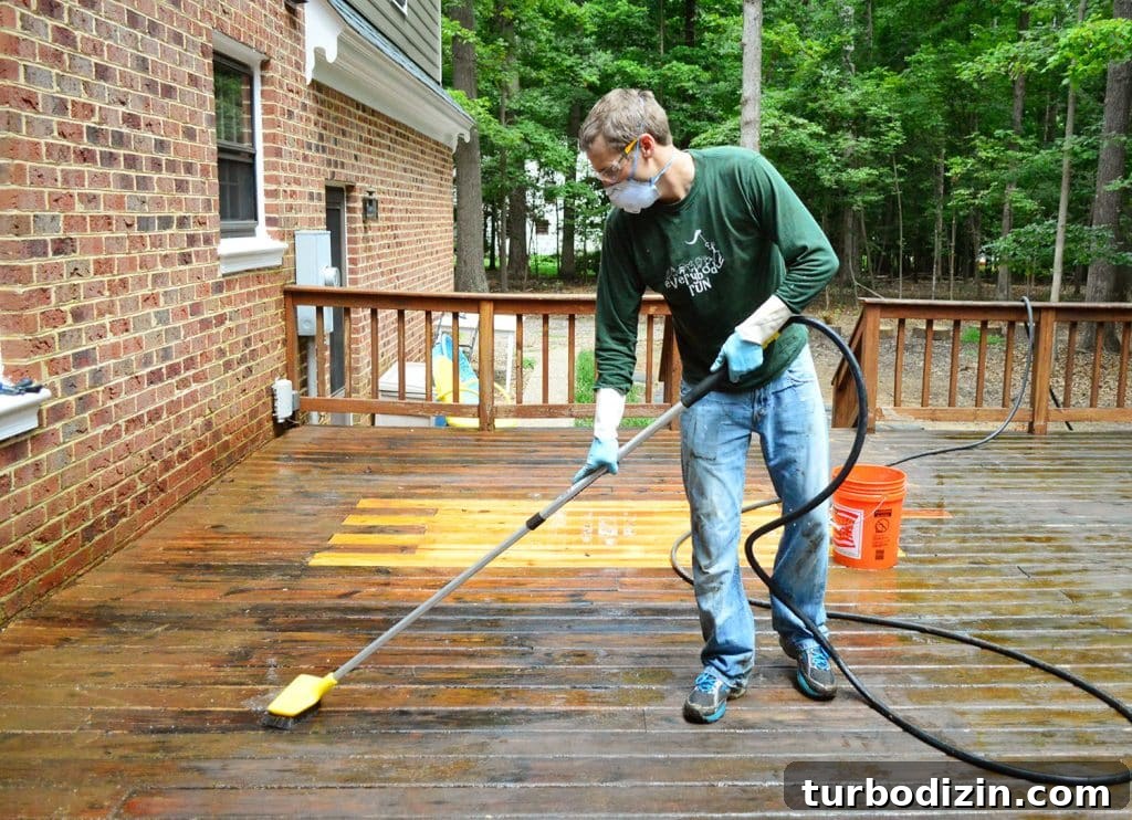John scrubbing deck with brush attached to hose