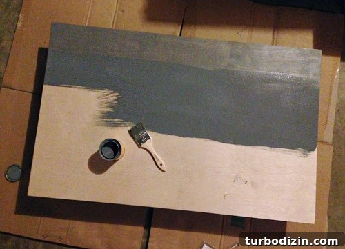 4 DIY Holiday Crafts to Transform Your Home This Season 4 Staining a piece of plywood gray with a brush to make a faux fireplace mantle